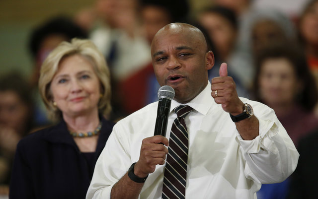 Denver Mayor Michael Hancock, front, introduces Democratic presidential candidate Hillary Rodham Clinton during a rally Tuesday, Nov. 24, 2015, in a high school gymnasium in Denver. (AP Photo/David Zalubowski)